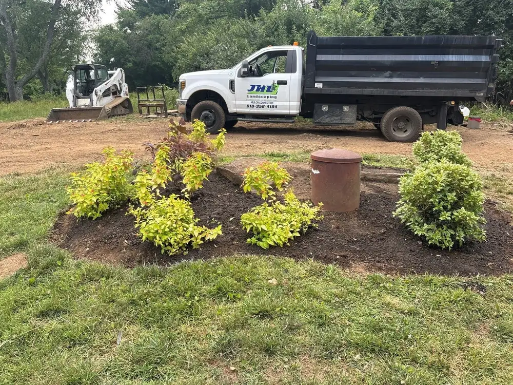 New island bed of gold spirea with the JHL Landscape Design truck on site